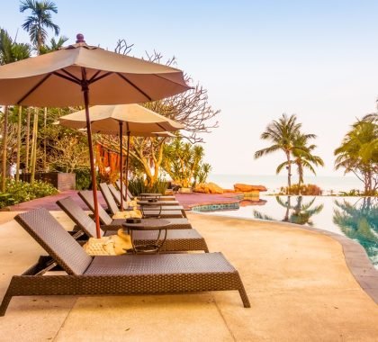 Beautiful luxury swimming pool with palm tree and sea background in hotel pool resort - Vintage Filter and Boost up color Processing